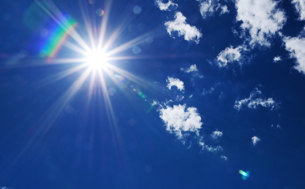 Bright Sunlight with Natural Lens Flare and Radiating Rays in a Blue Summer Sky
